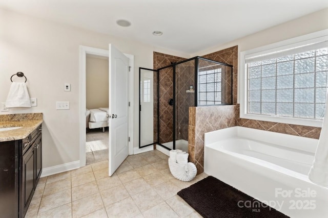 ensuite bathroom featuring ensuite bath, tile patterned floors, a garden tub, vanity, and a shower stall