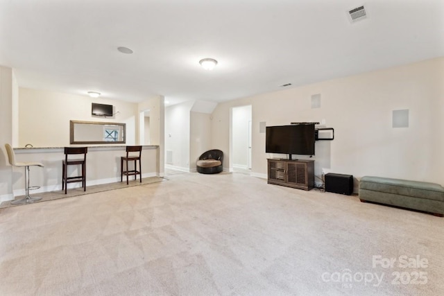 living room featuring carpet flooring, visible vents, and baseboards