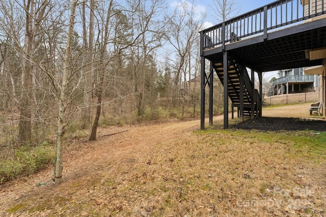 view of yard featuring stairs, a carport, and a deck