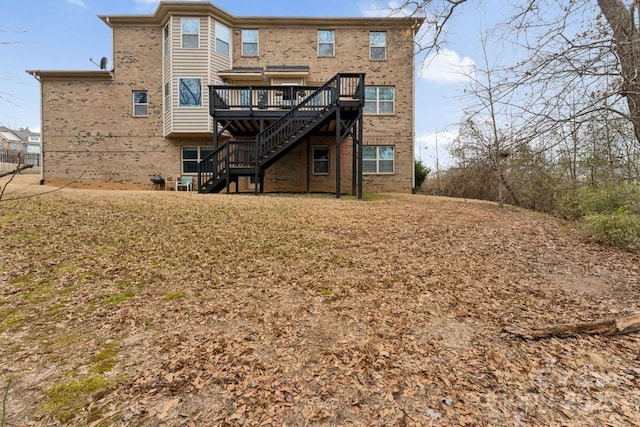 back of property featuring brick siding, a deck, and stairs