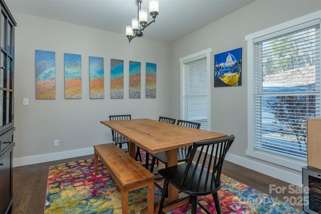 dining room with dark hardwood / wood-style flooring and a notable chandelier