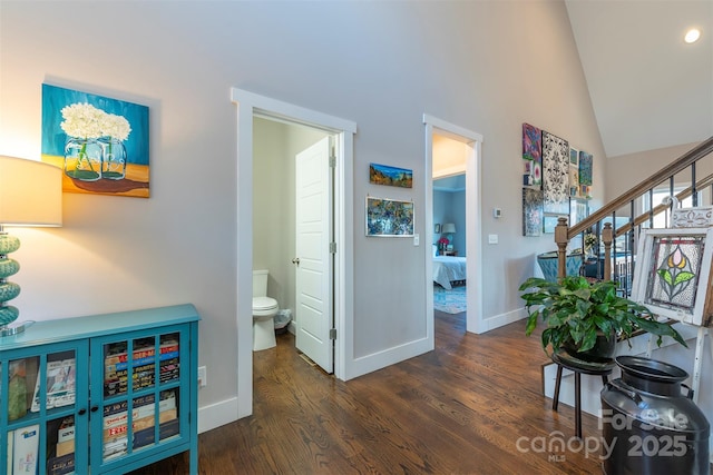 hall featuring lofted ceiling and dark wood-type flooring