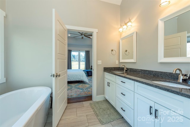 bathroom featuring a bathing tub, vanity, and ceiling fan