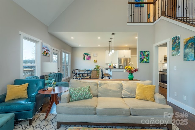 living room with wood-type flooring, sink, and high vaulted ceiling