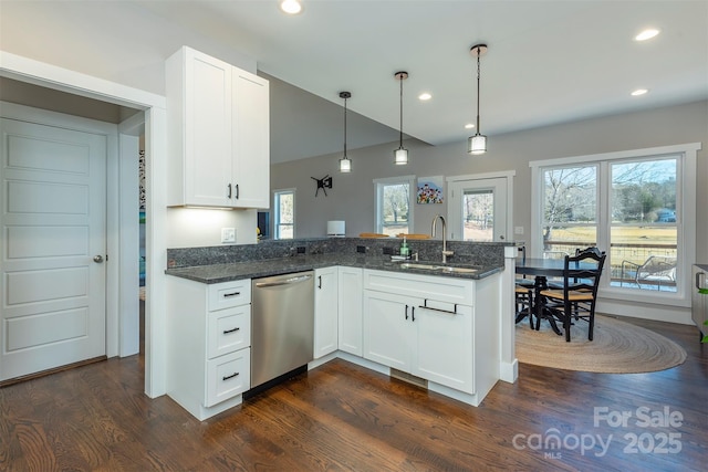 kitchen with white cabinetry, sink, stainless steel dishwasher, and dark stone counters