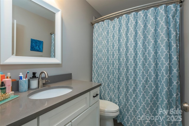 bathroom featuring vanity, toilet, and curtained shower