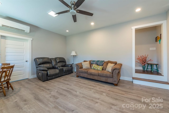 living room featuring ceiling fan, a wall mounted air conditioner, and light hardwood / wood-style floors