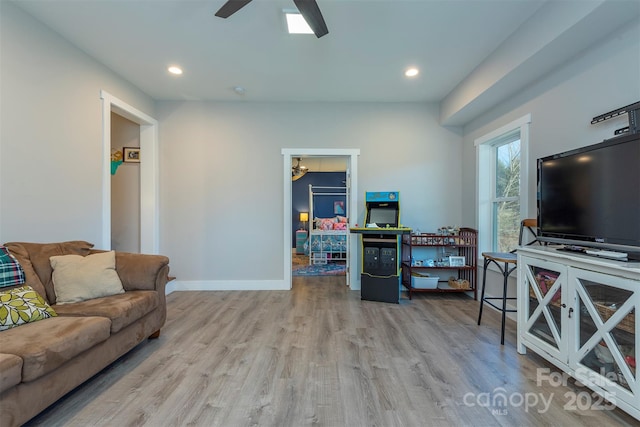 living room with light hardwood / wood-style floors and ceiling fan