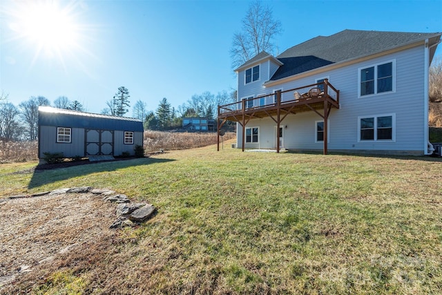 rear view of property with an outbuilding, a yard, and a wooden deck