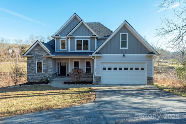 craftsman inspired home featuring a garage, a front yard, and covered porch