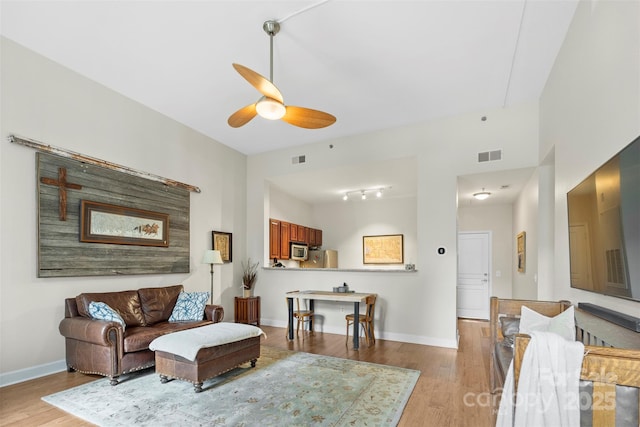 living room with light hardwood / wood-style flooring and ceiling fan