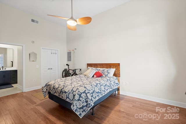 bedroom with ensuite bathroom, a closet, high vaulted ceiling, light hardwood / wood-style flooring, and ceiling fan