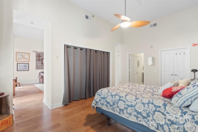 bedroom with ceiling fan, high vaulted ceiling, and light wood-type flooring