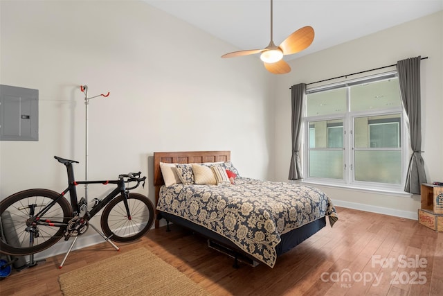 bedroom with ceiling fan, hardwood / wood-style floors, and electric panel