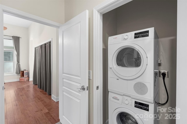 laundry area featuring hardwood / wood-style floors and stacked washer and clothes dryer