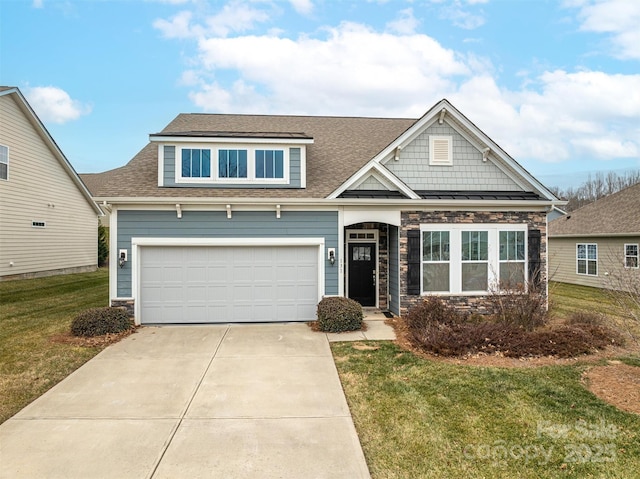 craftsman-style house featuring a garage and a front lawn