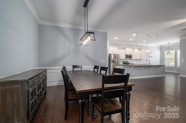 dining room featuring sink, crown molding, and dark hardwood / wood-style flooring