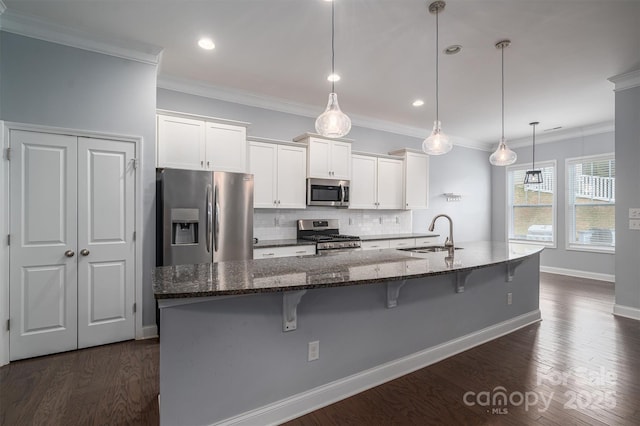 kitchen with sink, a kitchen island with sink, white cabinets, and appliances with stainless steel finishes