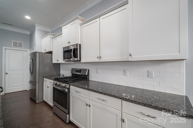 kitchen featuring white cabinets, appliances with stainless steel finishes, and decorative backsplash