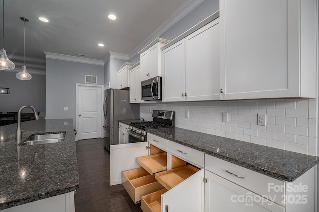 kitchen featuring sink, decorative light fixtures, white cabinetry, dark stone countertops, and stainless steel appliances