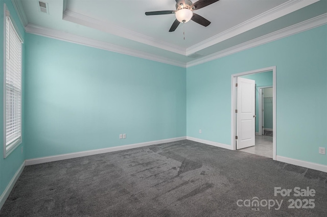 carpeted spare room featuring ceiling fan, a tray ceiling, and ornamental molding