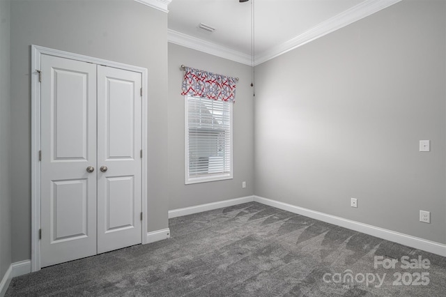 unfurnished bedroom featuring crown molding, dark colored carpet, and a closet