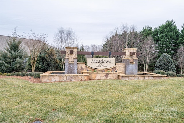 community sign featuring a yard