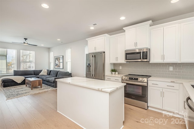 5048 York Park Ln, Charlotte, NC 28217 - kitchen featuring white cabinetry, a kitchen island, visible vents, light wood-style flooring, and appliances with stainless steel finishes
