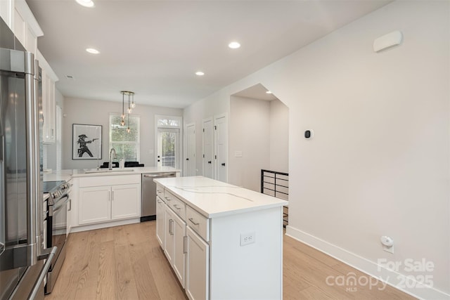 5048 York Park Ln, Charlotte, NC 28217 - kitchen featuring a sink, light wood-style floors, a kitchen island, and appliances with stainless steel finishes