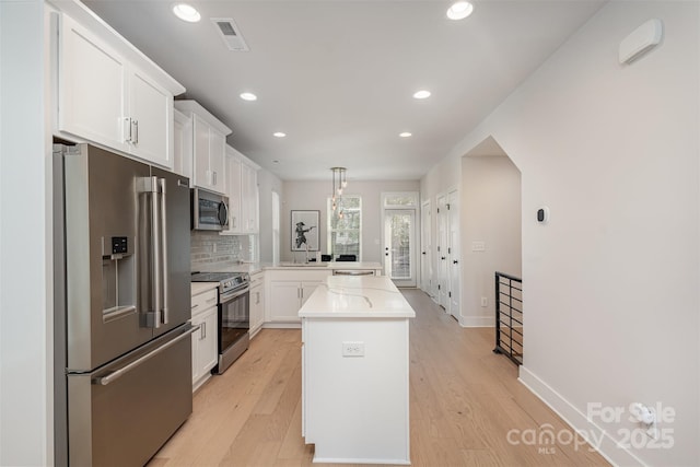 5048 York Park Ln, Charlotte, NC 28217 - kitchen featuring a sink, a peninsula, stainless steel appliances, visible vents, and white cabinets