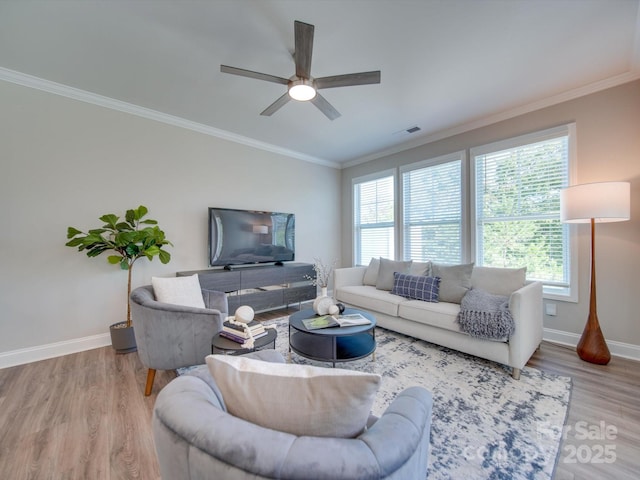 living room with hardwood / wood-style floors, a healthy amount of sunlight, and ornamental molding