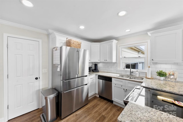 kitchen with white cabinetry, stainless steel appliances, light stone countertops, and sink