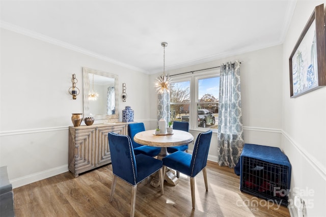 dining room featuring an inviting chandelier, hardwood / wood-style floors, and ornamental molding