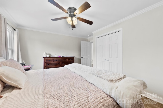 bedroom with hardwood / wood-style floors, ornamental molding, a closet, and ceiling fan