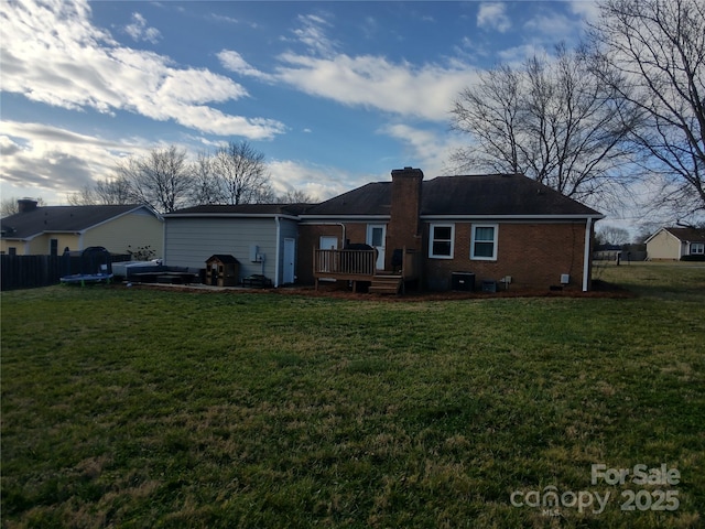 rear view of house with a wooden deck and a yard