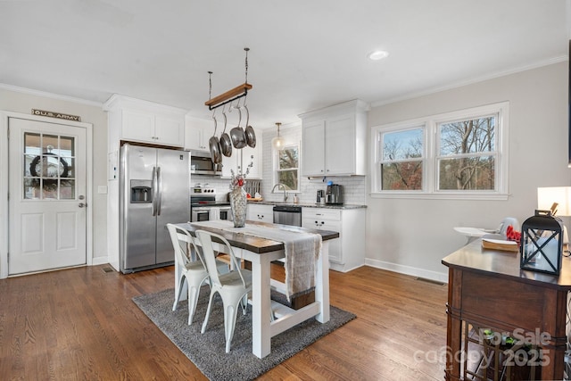 kitchen featuring stainless steel appliances, white cabinetry, tasteful backsplash, and dark hardwood / wood-style floors