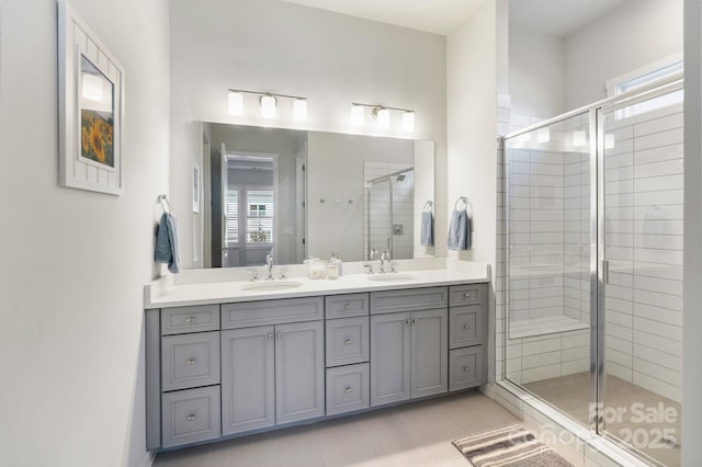 bathroom featuring tile patterned flooring, vanity, and a shower with door