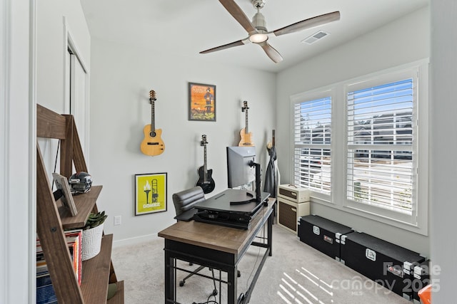 carpeted office space with ceiling fan