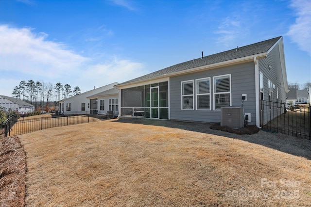 rear view of house featuring central AC, a sunroom, and a yard