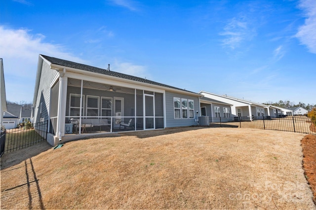 rear view of house with a yard, a sunroom, central air condition unit, and ceiling fan