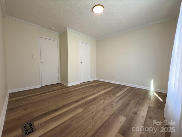 unfurnished bedroom featuring wood-type flooring, ornamental molding, a textured ceiling, and a closet