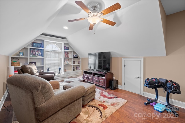 living room featuring wood-type flooring, built in shelves, ceiling fan, and vaulted ceiling