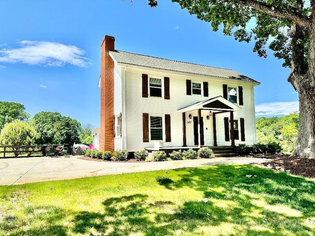 colonial inspired home featuring a front lawn