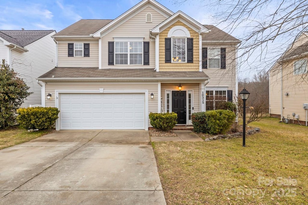 view of front of property with a garage and a front lawn