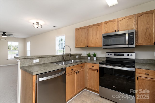 kitchen with sink, stainless steel appliances, ceiling fan, and kitchen peninsula