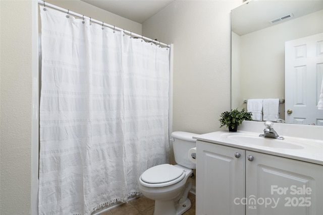 bathroom with toilet, tile patterned floors, and vanity