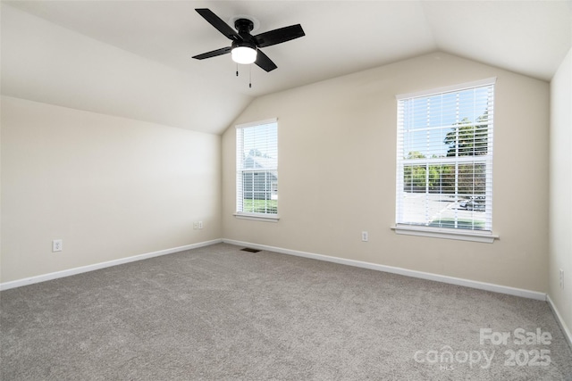 spare room with ceiling fan, carpet flooring, and vaulted ceiling