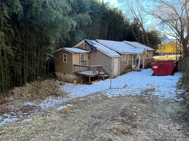 snow covered house featuring a wooden deck