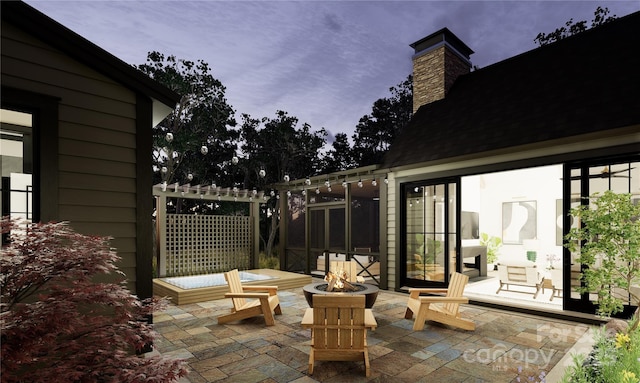 patio terrace at dusk featuring an outdoor fire pit