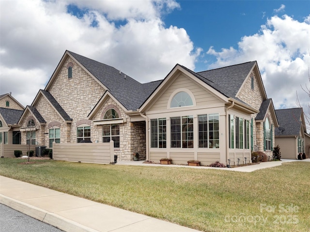 view of front of home with central air condition unit and a front lawn